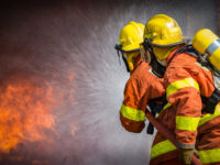 2 firefighters spraying high pressure water to fire with copy space 2 firefighters spraying high pressure water to fire with copy space
